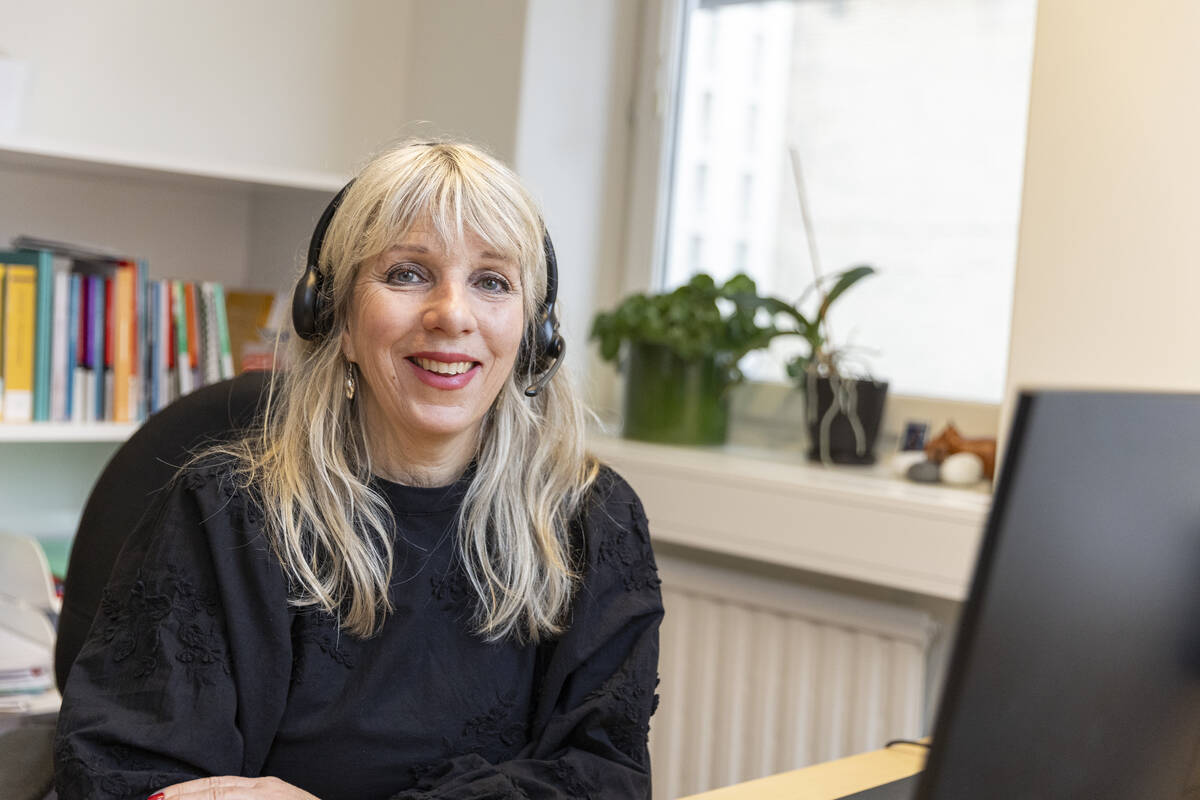 En bemötande kvinna med headset på kontor 